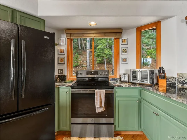 a kitchen with granite countertop a refrigerator stove and sink