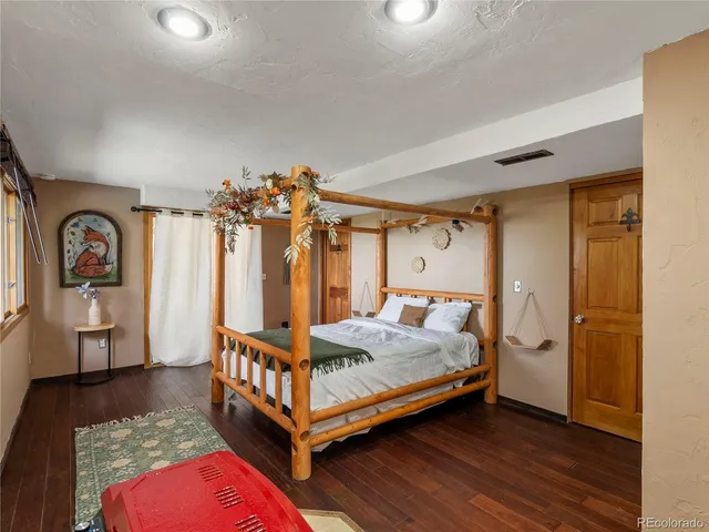 a bedroom with a bed and wooden floor