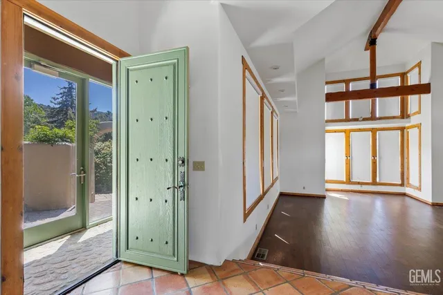 a view of a hallway with wooden floor and a living room
