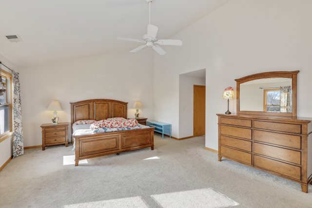 1350 Hunters Ridge West Hoffman Estates, IL 60192 - Photo 22 of 41 a bedroom with a bed and a chandelier