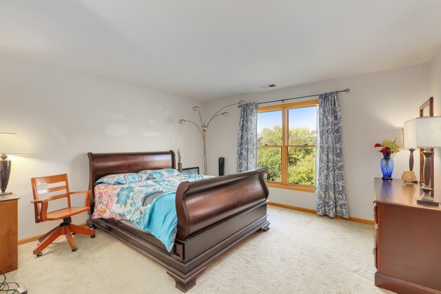 1350 Hunters Ridge West Hoffman Estates, IL 60192 - Photo 26 of 41 a bedroom with a bed and a large window