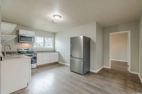 a kitchen with stainless steel appliances granite countertop wooden cabinets and a stove top oven