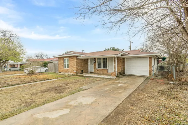 front view of a house with a yard and trees
