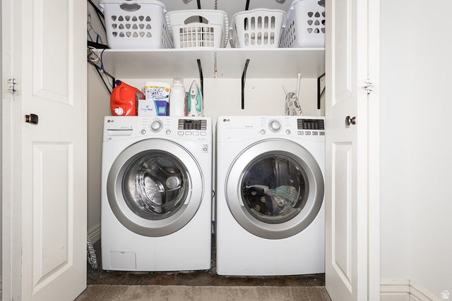 7797 North Windhover Road Eagle Mountain, UT 84005 - Photo 26 of 33 Dedicated laundry closet featuring a stackable washer and dryer, white shelving, and bi-fold doors