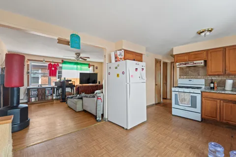 a kitchen that has a lot of white cabinets and stainless steel appliances