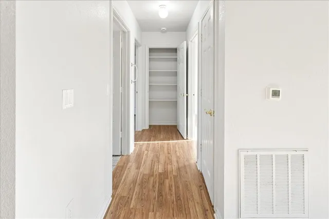 a view of a hallway with wooden floor