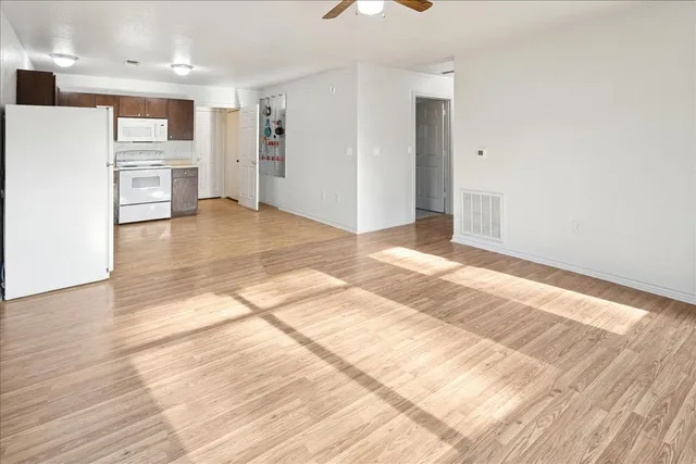 a view of a kitchen with wooden floor and a refrigerator