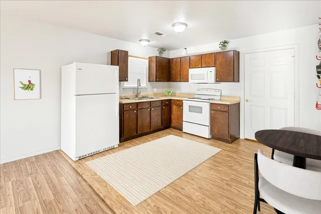 a kitchen with granite countertop a refrigerator stove top oven and sink