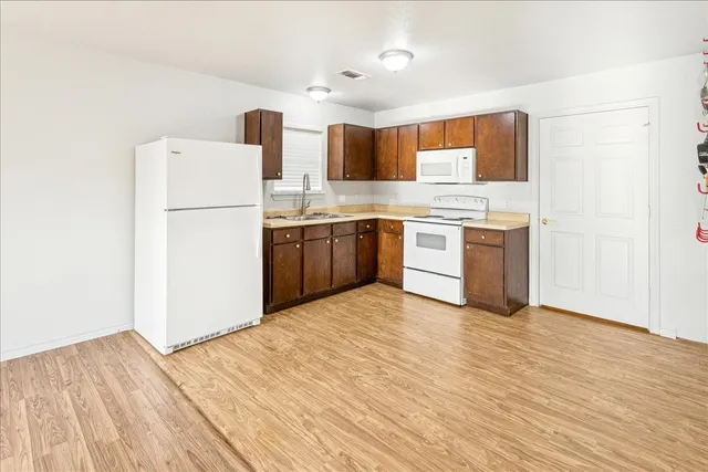 a kitchen with stainless steel appliances granite countertop a refrigerator sink and stove