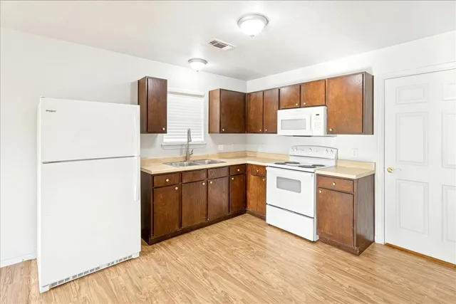 a kitchen with a refrigerator sink stove and cabinets