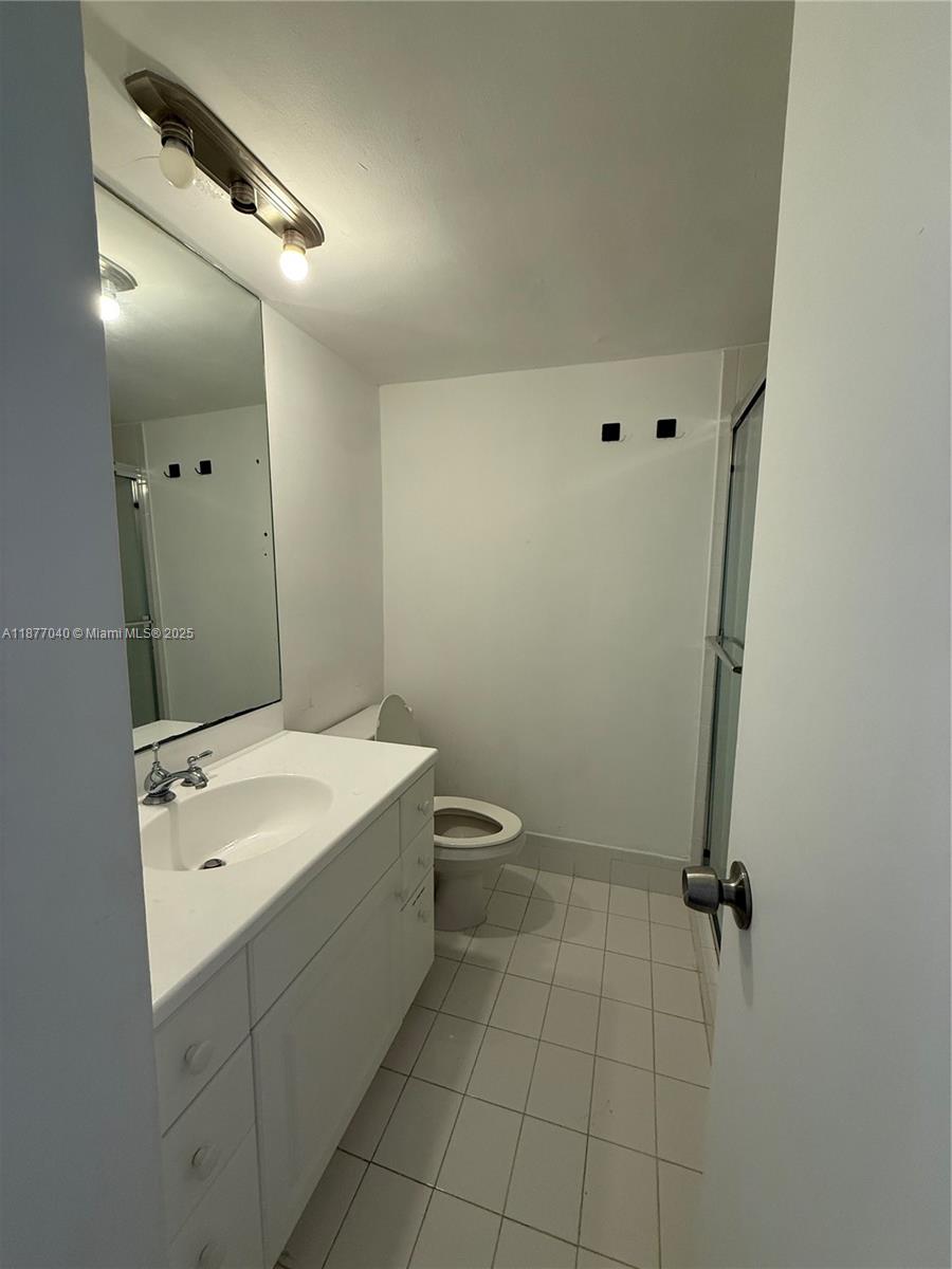 5161 Collins Avenue, Unit 511 Miami Beach, FL 33140 - Photo 9 of 29 a bathroom with a sink a toilet and mirror