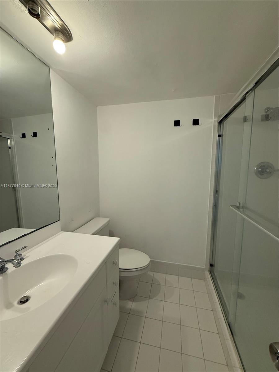 5161 Collins Avenue, Unit 511 Miami Beach, FL 33140 - Photo 10 of 29 a bathroom with a sink a toilet and shower