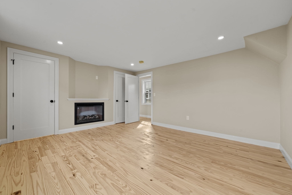 162 High Street, Unit B Danvers, MA 01923 - Photo 20 of 32 a view of empty room with wooden floor and fireplace