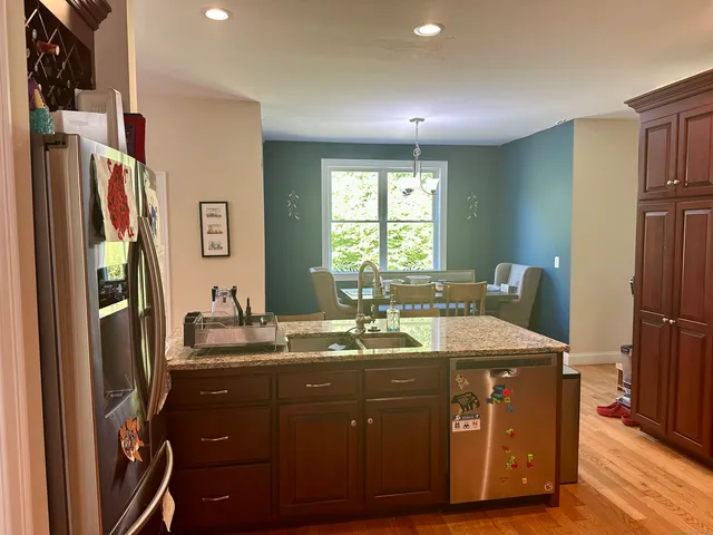 a room with a sink a refrigerator and a window