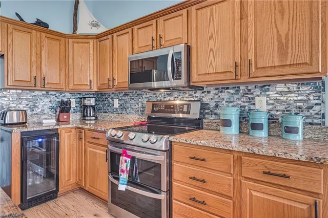 a kitchen with stainless steel appliances granite countertop a sink stove and cabinets
