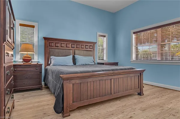 a bedroom with a bed and a dresser next to a window