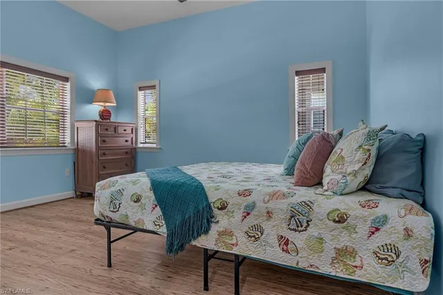 a bedroom with a bed a dresser with wooden floor