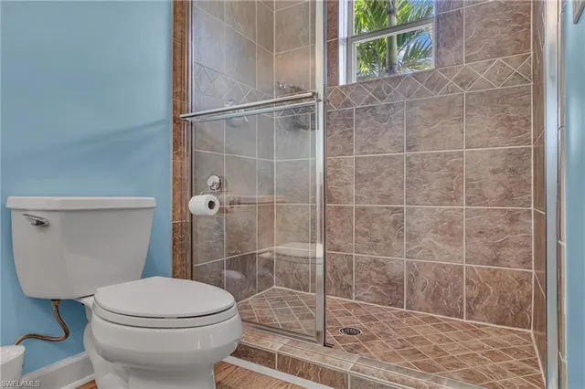 a bathroom with a toilet and a shower