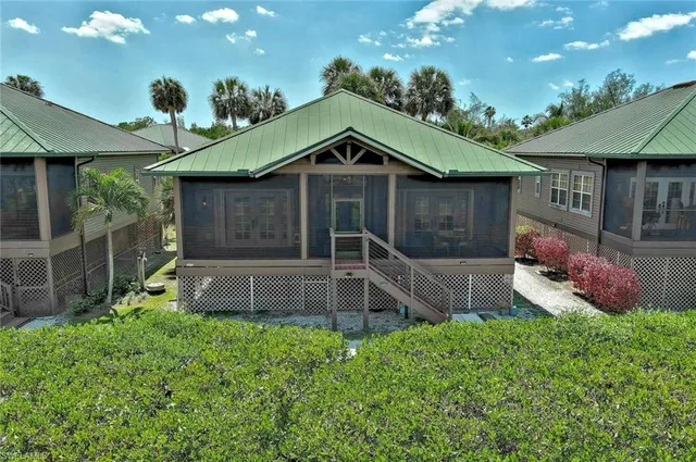 a front view of a house with a yard and potted plants