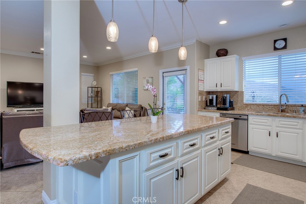 16163 Setting Sun Circle Riverside, CA 92503 - Photo 11 of 36 a kitchen with granite countertop a sink a center island and stainless steel appliances