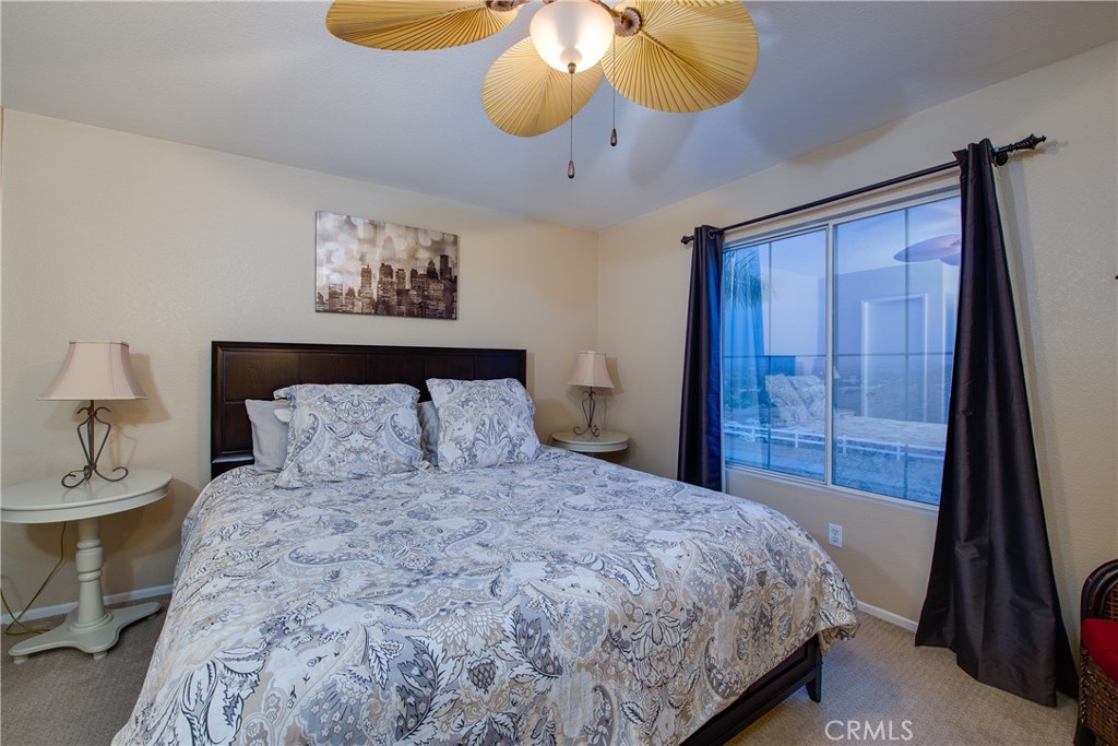 16163 Setting Sun Circle Riverside, CA 92503 - Photo 21 of 36 a bedroom with a bed and a chandelier
