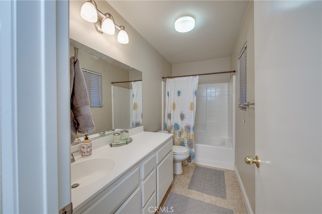 16163 Setting Sun Circle Riverside, CA 92503 - Photo 26 of 36 a bathroom with a double vanity sink toilet mirror and shower