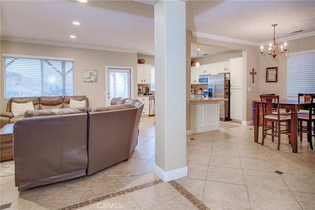 16163 Setting Sun Circle Riverside, CA 92503 - Photo 8 of 36 a living room with furniture and a dining table with kitchen appliances