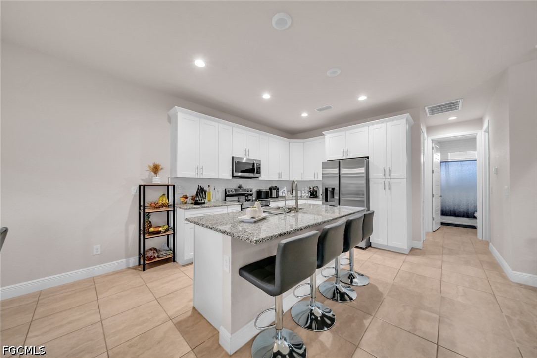 384 Neighborly Road LaBelle, FL 33935 - Photo 14 of 45 a kitchen with stainless steel appliances kitchen island granite countertop a sink and cabinets