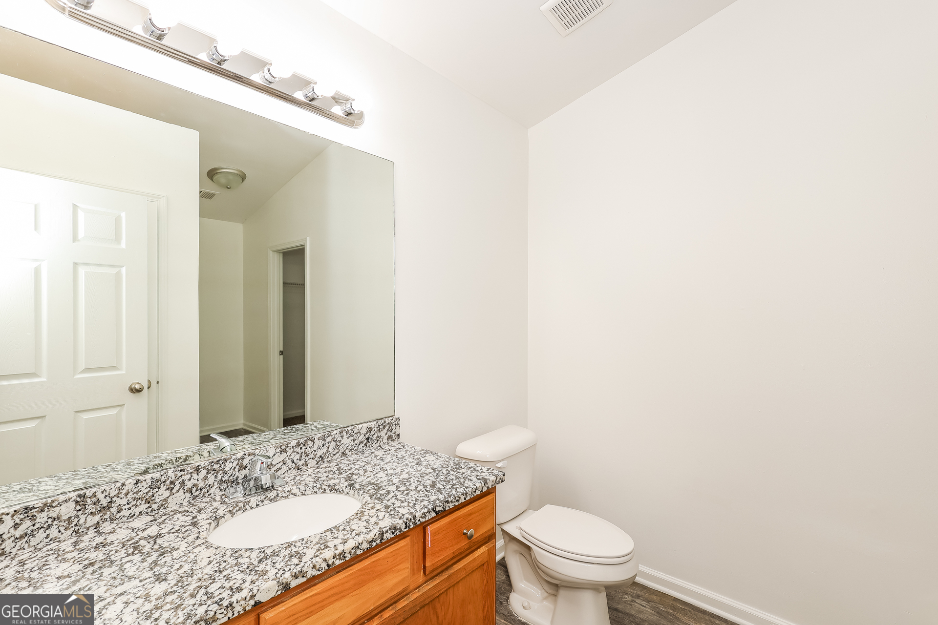 138 Pope Lane Newnan, GA 30263 - Photo 21 of 25 a bathroom with a granite countertop sink a toilet and a mirror