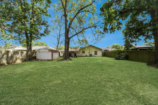a living room with furniture kitchen view and a large window