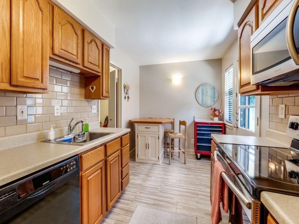 10755 Villager Road, Unit B Dallas, TX 75230 - Photo 7 of 24 a kitchen with stainless steel appliances granite countertop a stove and cabinets