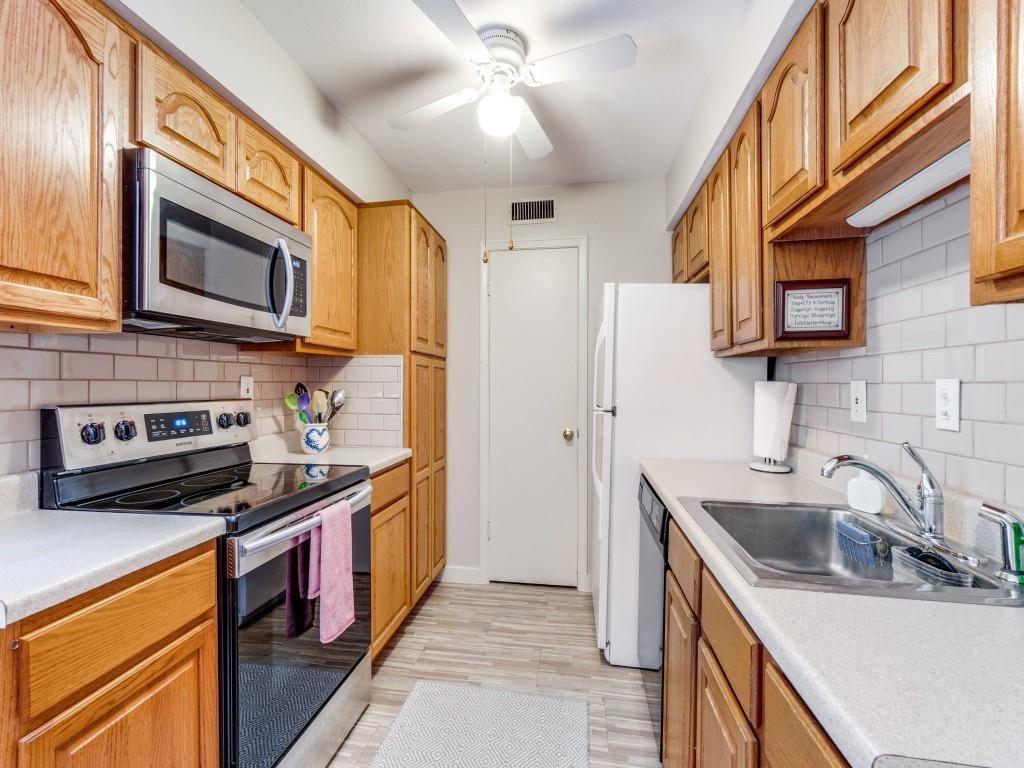 10755 Villager Road, Unit B Dallas, TX 75230 - Photo 8 of 24 a kitchen with stainless steel appliances granite countertop a sink stove and refrigerator