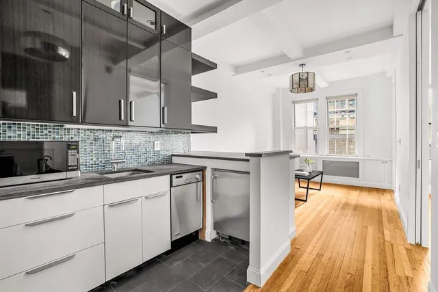 a kitchen with cabinets and wooden floor