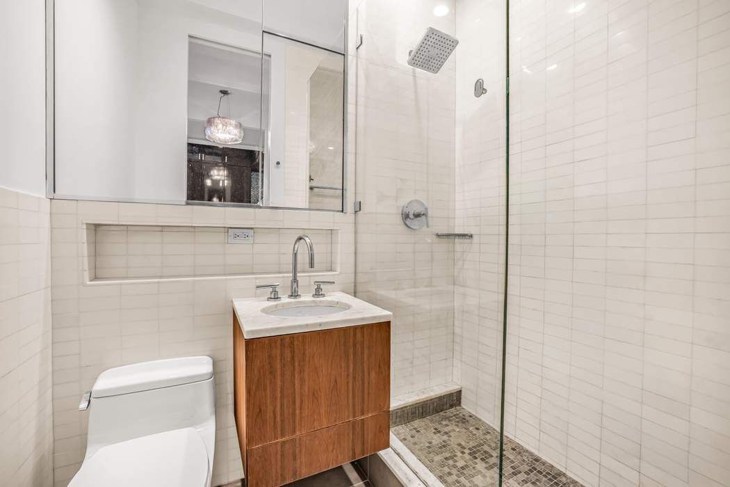 66 Madison Avenue, Unit 9C Manhattan, NY 10016 - Photo 5 of 7 a bathroom with a sink a toilet and shower
