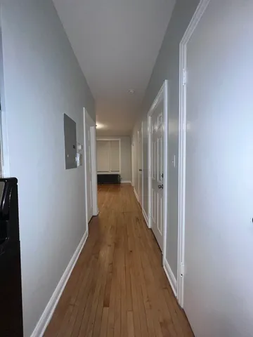 a view of a hallway with wooden floor