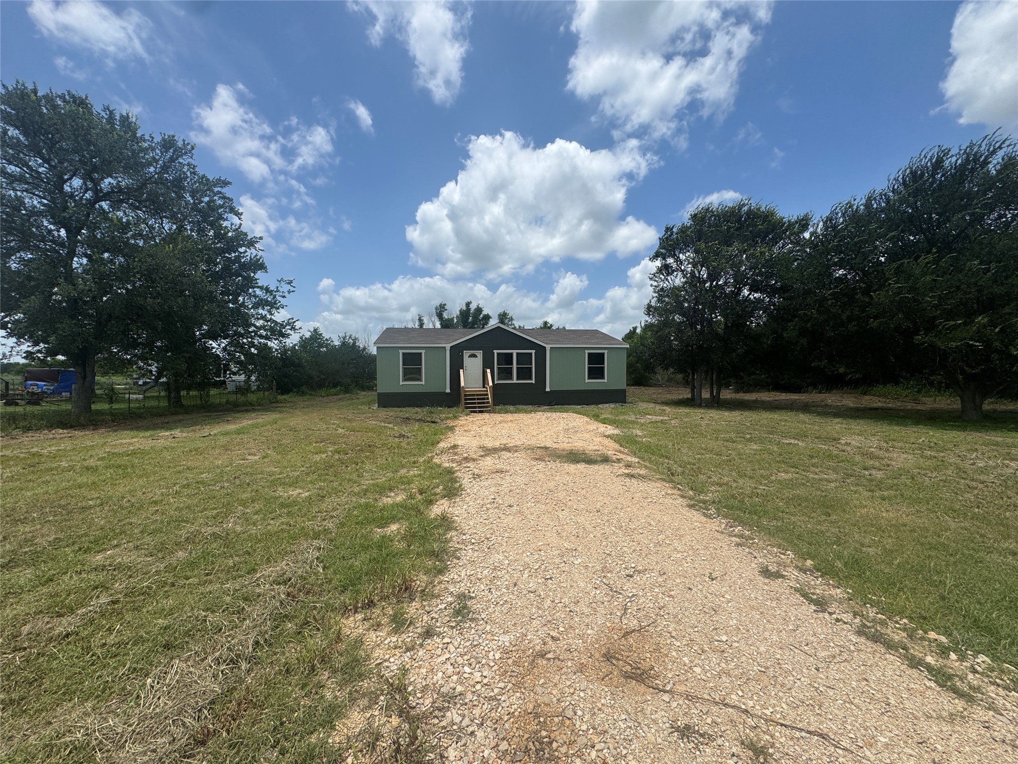 7855 Taylorsville Road Dale, TX 78616 - Photo 1 of 11 A secluded residence with a gravel drive, nestled amidst natural landscaping and mature shade trees.