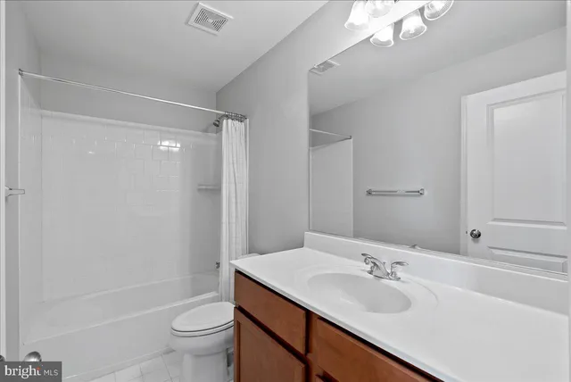 an empty room with windows and chandelier fan