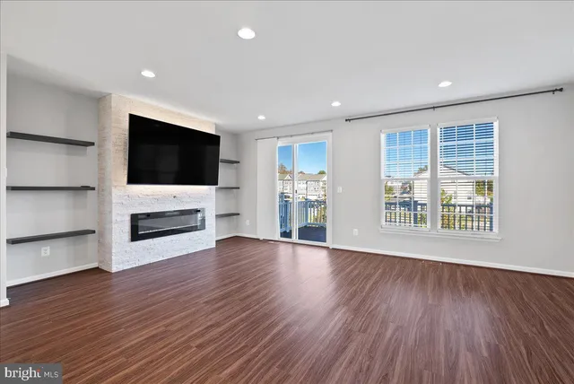 a view of a livingroom with a flat screen tv wooden floor and a fireplace