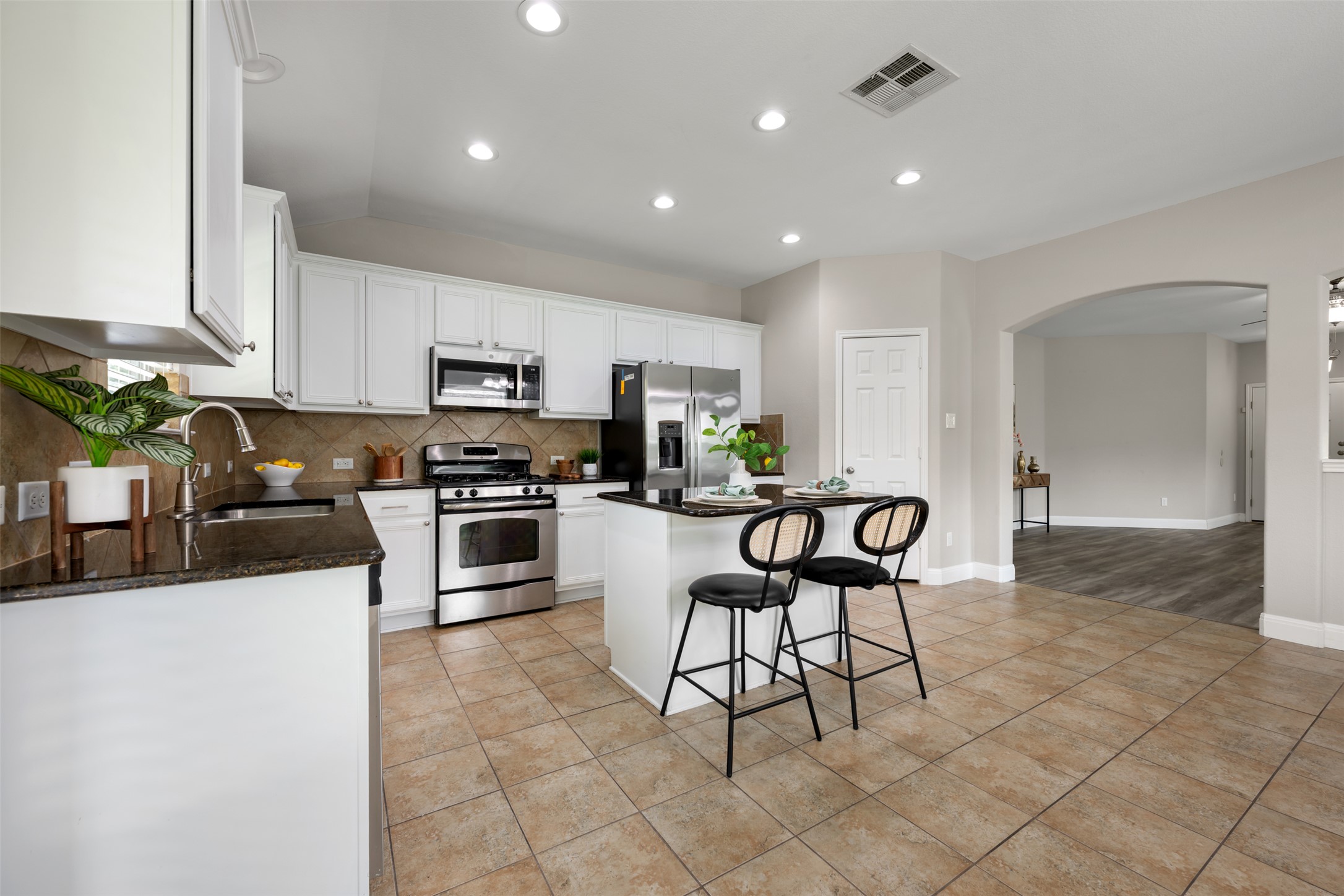 18820 Edinburgh Castle Road Pflugerville, TX 78660 - Photo 17 of 37 a kitchen with granite countertop a stove a sink and a microwave