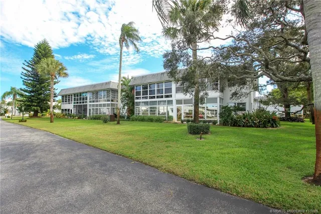 a view of a house with a big yard and large trees