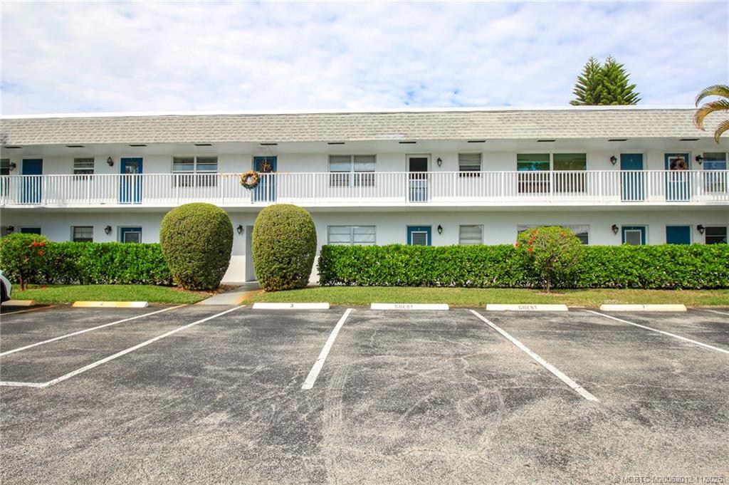 2929 Southeast Ocean Boulevard, Unit 1189 Stuart, FL 34996 - Photo 25 of 34 a front view of a house with a yard and garage