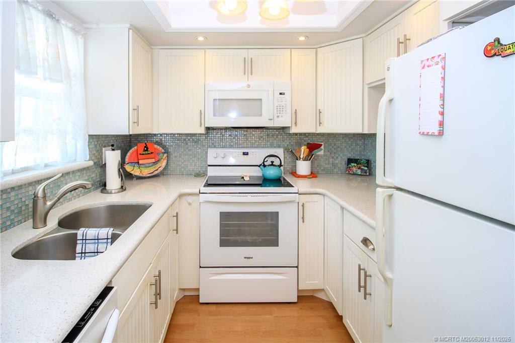 2929 Southeast Ocean Boulevard, Unit 1189 Stuart, FL 34996 - Photo 5 of 34 a kitchen with stainless steel appliances granite countertop a sink and a stove top oven