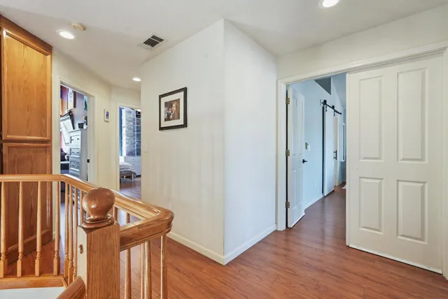 a view of a hallway with entryway and wooden floor
