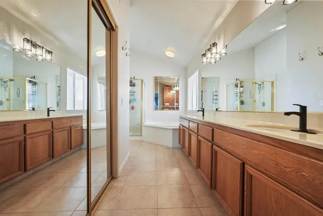 a large bathroom with a sink a mirror a bathtub and shower