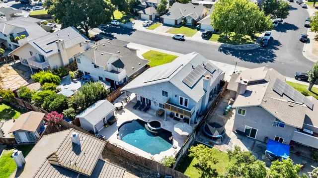 an aerial view of a house with a swimming pool and outdoor seating