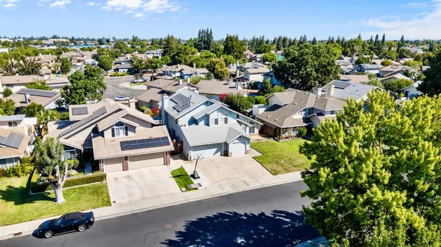 an aerial view of a house with a garden and a car parked in the background
