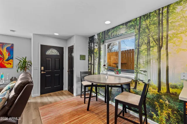 a kitchen with stainless steel appliances granite countertop a refrigerator a sink dishwasher a stove and a dining table with wooden floor