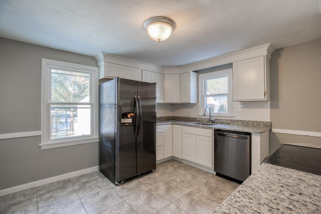 110 Gilman Street Springfield, MA 01118 - Photo 3 of 24 a kitchen with granite countertop stainless steel appliances a refrigerator cabinets and window