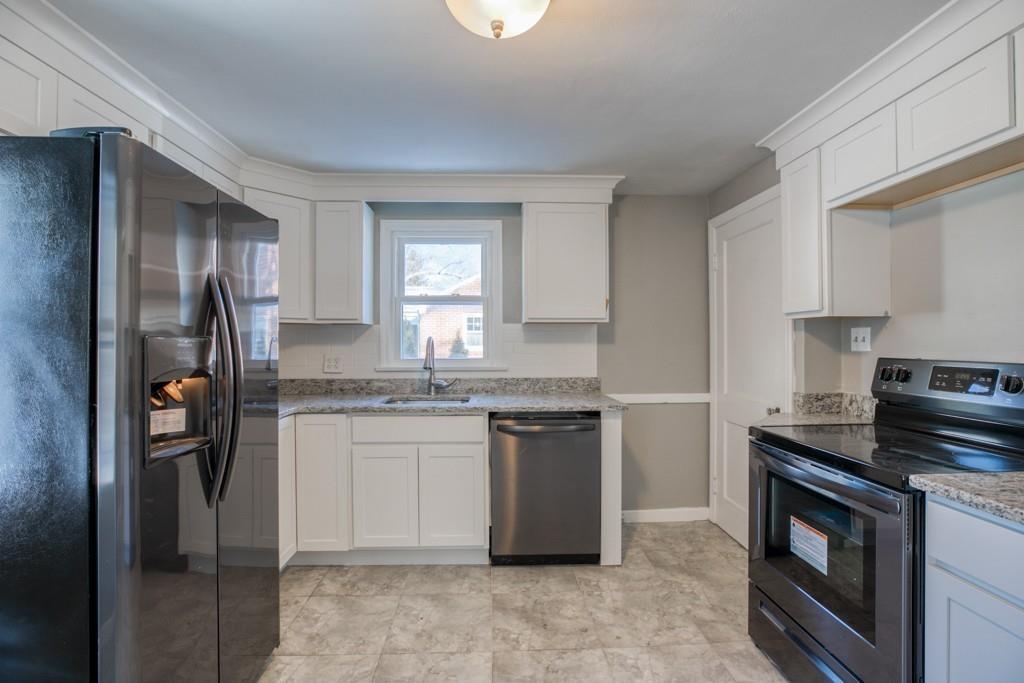 110 Gilman Street Springfield, MA 01118 - Photo 6 of 24 a kitchen with stainless steel appliances granite countertop a stove a refrigerator and a sink