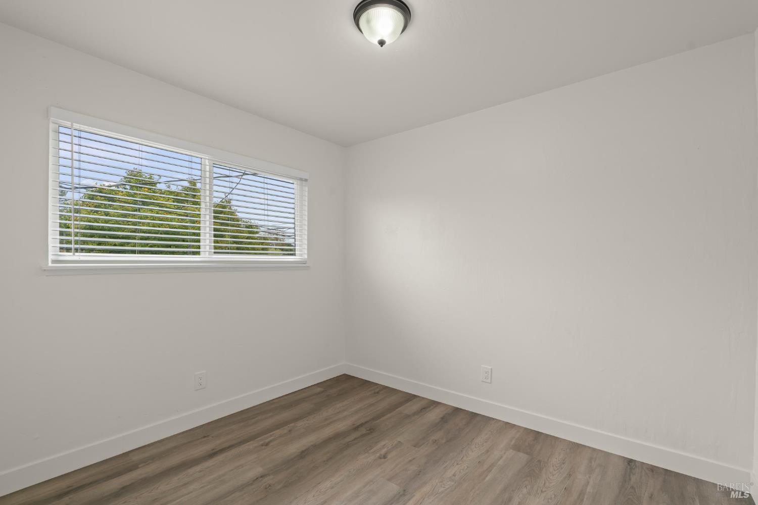 688 Grove Way Hayward, CA 94541 - Photo 13 of 20 a view of an empty room with wooden floor and a window